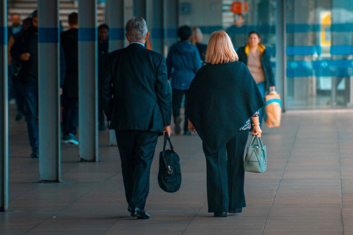 Main and woman walking away from camera at a London tube station.